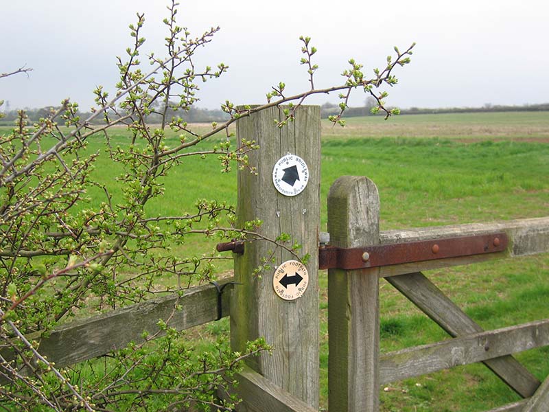 Gate post in field with footpath and bridleway notices
